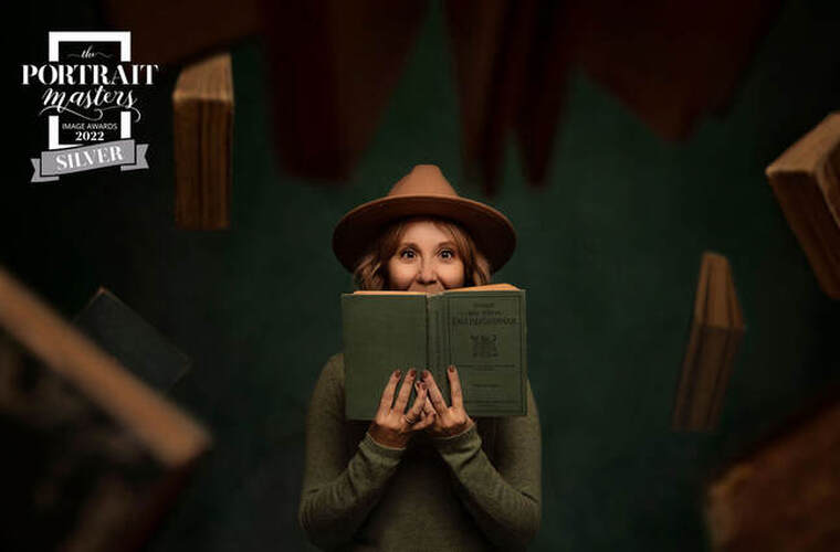 Photo of woman wearing wool hat with book in front of her face with books flying around. Greens and beige.