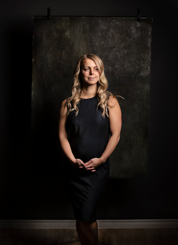 Photo of woman in studio in from of dark grey backdrop. Edmonton Portrait Photographer